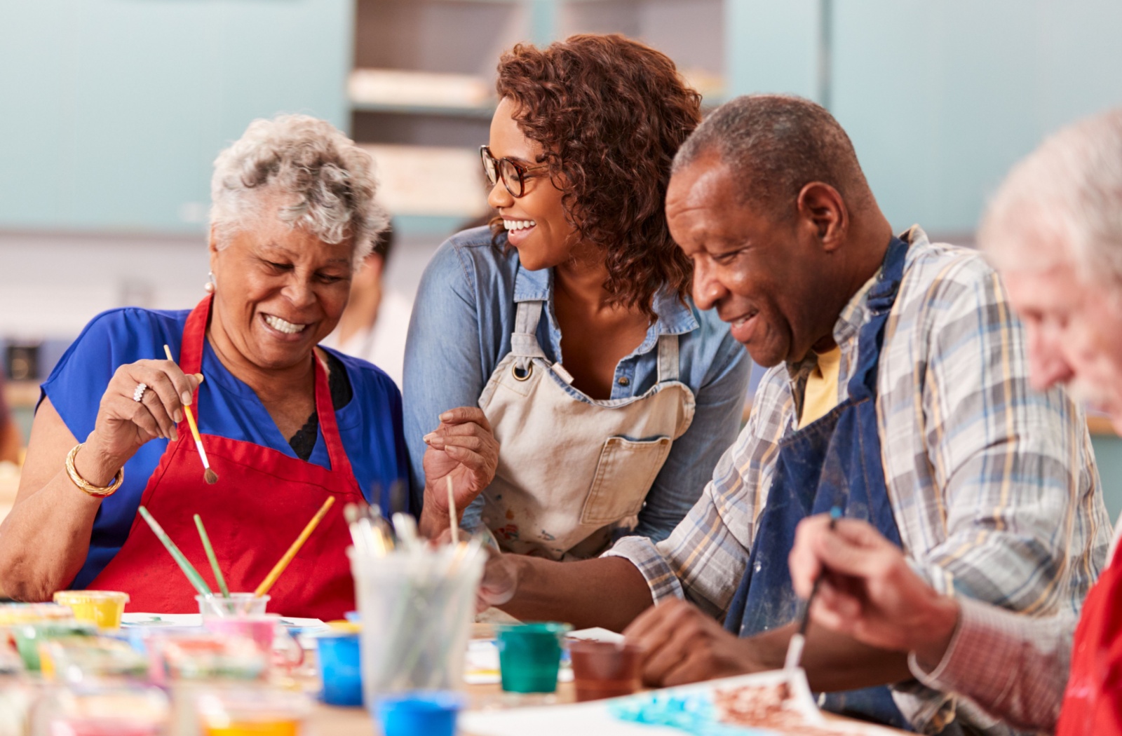 A group of older adults enjoy painting together in their senior living community.