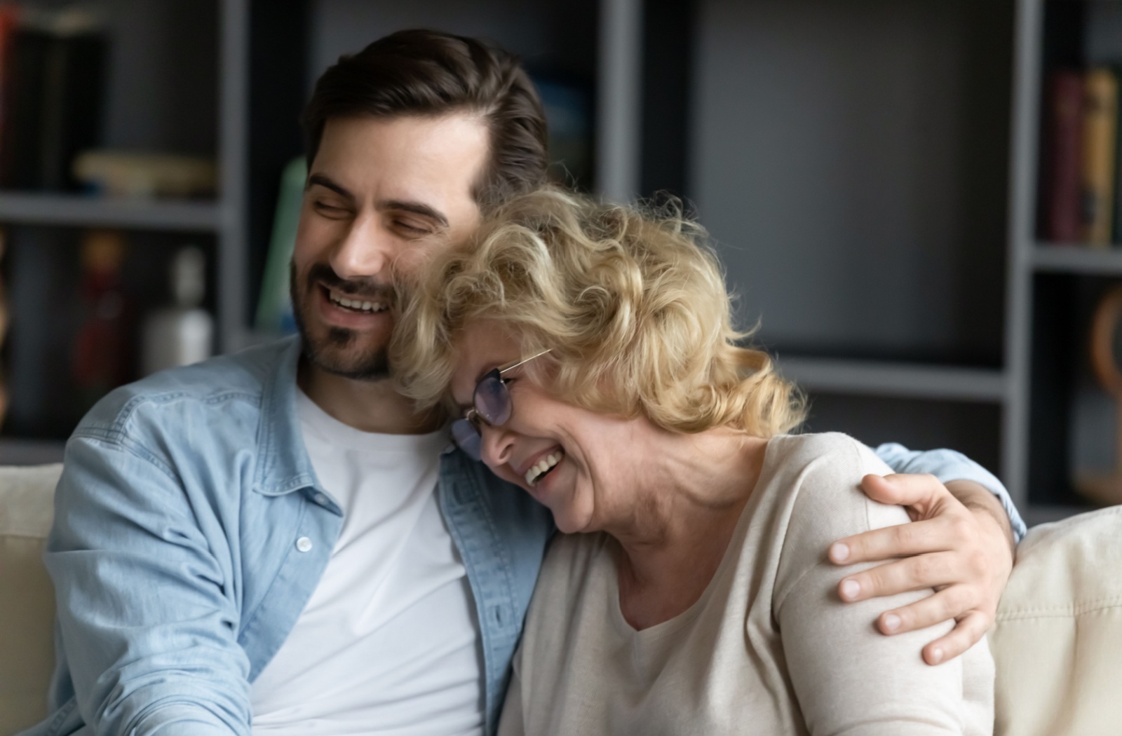 An adult child embracing their parent in assisted living.